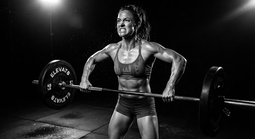 Member holding a loaded barbell in the ELEVAT8 strength hall